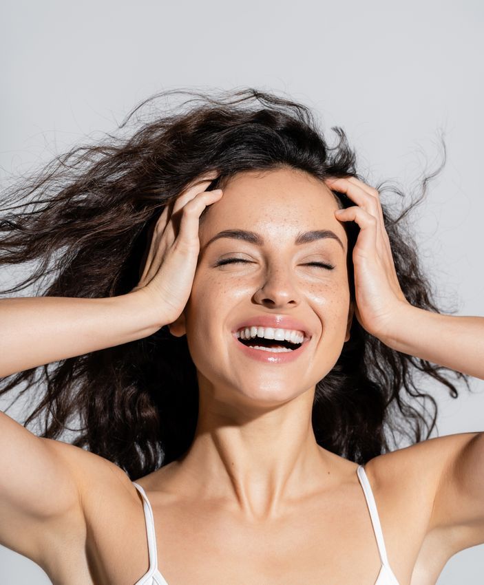 woman with wind-blown hair smiling